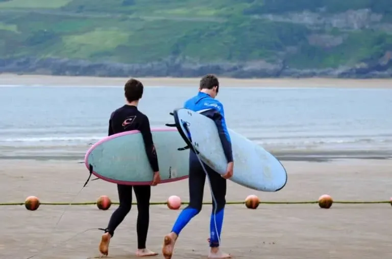 Deux hommes portant des planches de surf souples