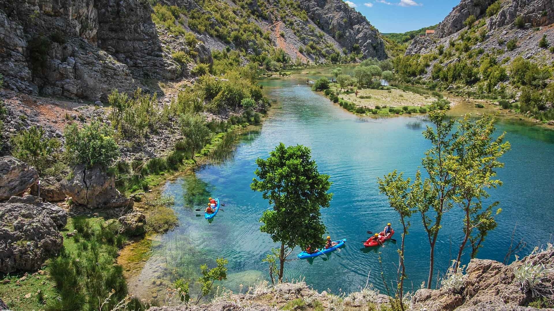 Kayakistes dans une rivière turquoise et claire dans la région de Dalmatie en Croatie.
